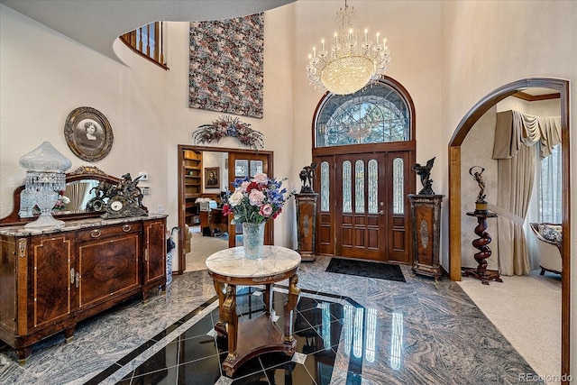 tiled foyer with an inviting chandelier and a towering ceiling