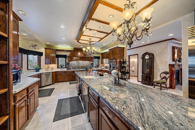 kitchen featuring an inviting chandelier, tasteful backsplash, stainless steel appliances, premium range hood, and hanging light fixtures