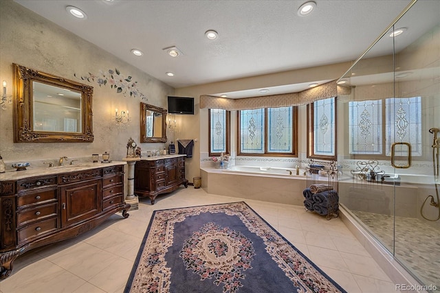 bathroom with independent shower and bath, large vanity, tile floors, and a textured ceiling