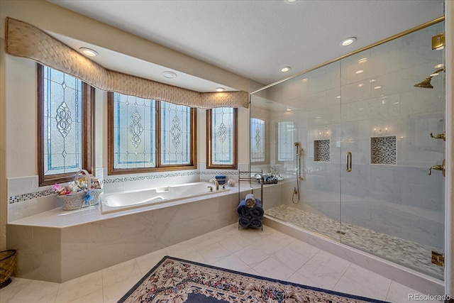 bathroom featuring tile flooring, separate shower and tub, and a textured ceiling