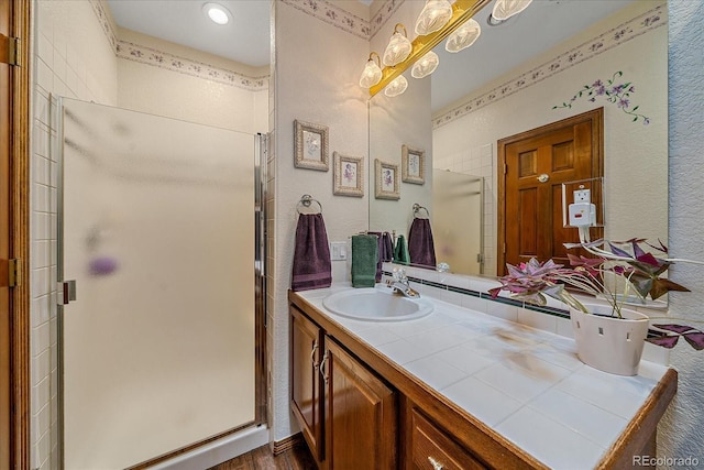 bathroom featuring walk in shower, vanity, and hardwood / wood-style flooring