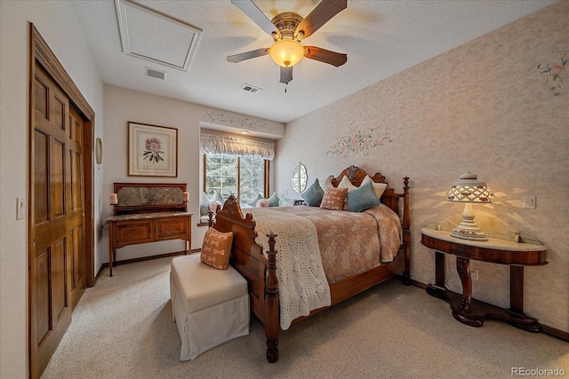 bedroom with ceiling fan, a textured ceiling, light colored carpet, and a closet