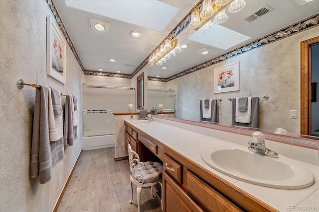 bathroom featuring dual bowl vanity and hardwood / wood-style flooring