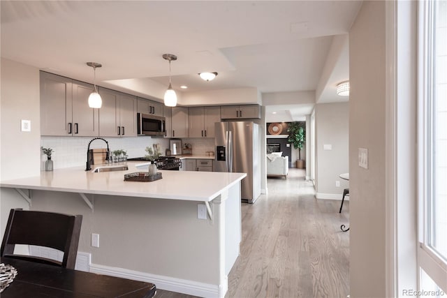 1772 Eisenhower, Louisville, CO 80027 - kitchen featuring appliances with stainless steel finishes, gray cabinets, a sink, light countertops, and a peninsula