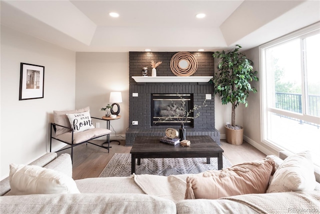 1772 Eisenhower, Louisville, CO 80027 - living area featuring a tray ceiling, a fireplace, wood finished floors, baseboards, and recessed lighting