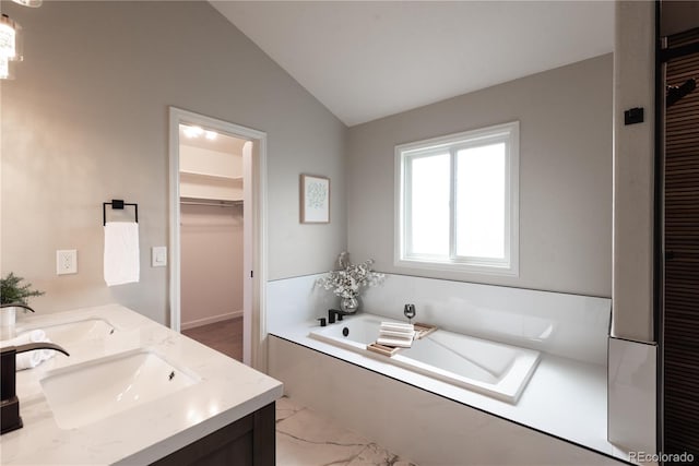 1772 Eisenhower, Louisville, CO 80027 - full bathroom featuring vaulted ceiling, a garden tub, double vanity, a walk in closet, and marble finish flooring