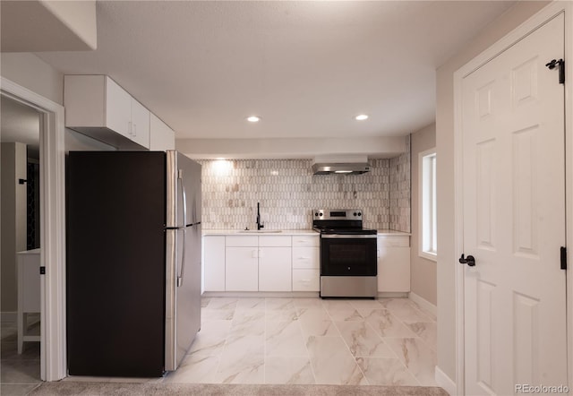 1772 Eisenhower, Louisville, CO 80027 - kitchen with stainless steel appliances, a sink, light countertops, white cabinetry, and wall chimney exhaust hood