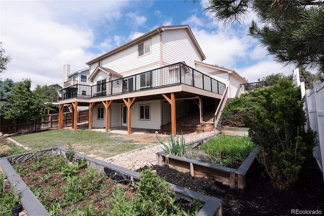 1772 Eisenhower, Louisville, CO 80027 - rear view of house featuring a vegetable garden, a wooden deck, and a patio