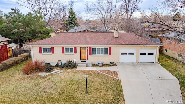 single story home with fence, concrete driveway, a front yard, an attached garage, and brick siding