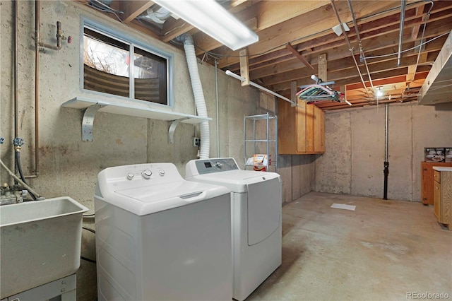 clothes washing area featuring a sink, laundry area, and washing machine and clothes dryer