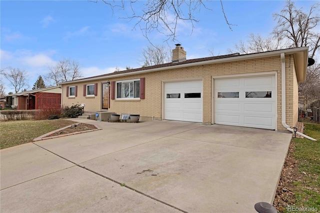 ranch-style home with brick siding, a chimney, concrete driveway, and an attached garage