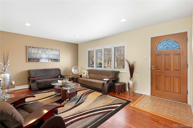 living area featuring a baseboard heating unit, recessed lighting, wood finished floors, and baseboards