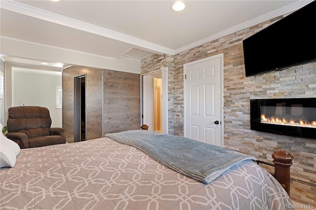 bedroom with a glass covered fireplace and crown molding