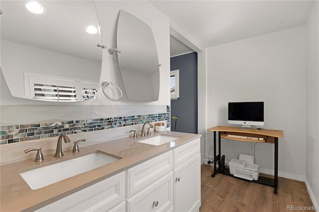 full bath featuring tasteful backsplash, double vanity, wood finished floors, and a sink