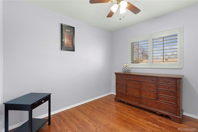 bedroom with ceiling fan, baseboards, and wood finished floors