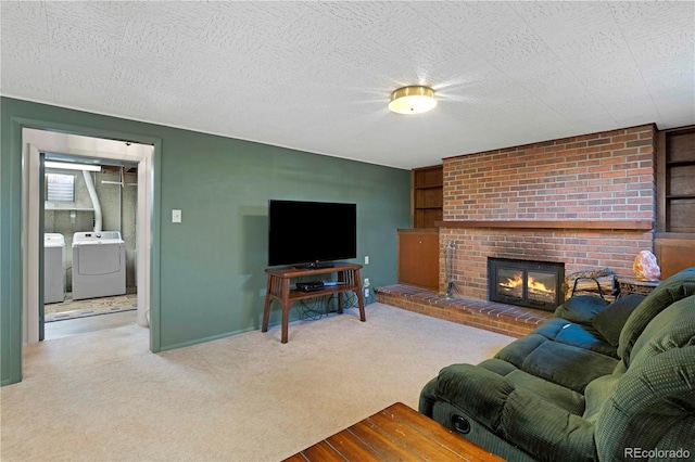 living area with a brick fireplace, carpet, independent washer and dryer, and a textured ceiling