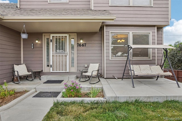7667 W Brook Dr, Littleton, CO 80128 - doorway to property featuring a porch and roof with shingles