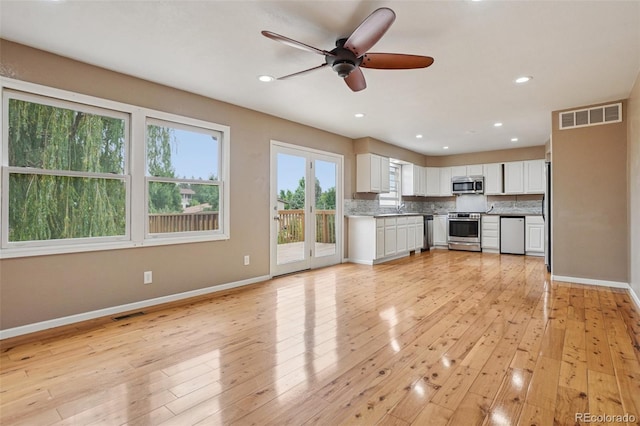 7667 W Brook Dr, Littleton, CO 80128 - unfurnished living room featuring a ceiling fan, light wood finished floors, and recessed lighting