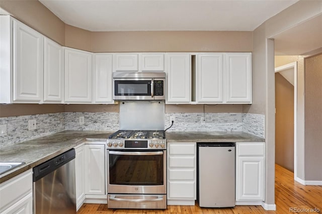 7667 W Brook Dr, Littleton, CO 80128 - kitchen with appliances with stainless steel finishes, white cabinets, and light wood-style floors