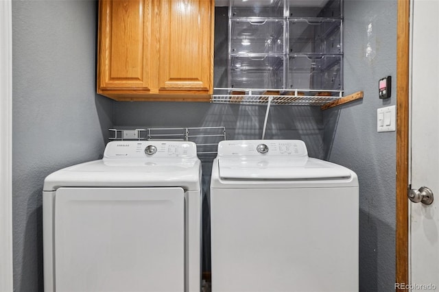 7667 W Brook Dr, Littleton, CO 80128 - laundry room featuring washer and clothes dryer, cabinet space, and a textured wall
