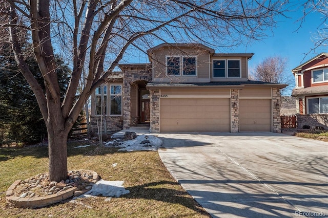 view of front facade featuring driveway, stone siding, and an attached garage