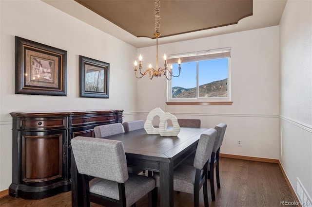 dining space featuring dark wood-style floors, an inviting chandelier, visible vents, and baseboards