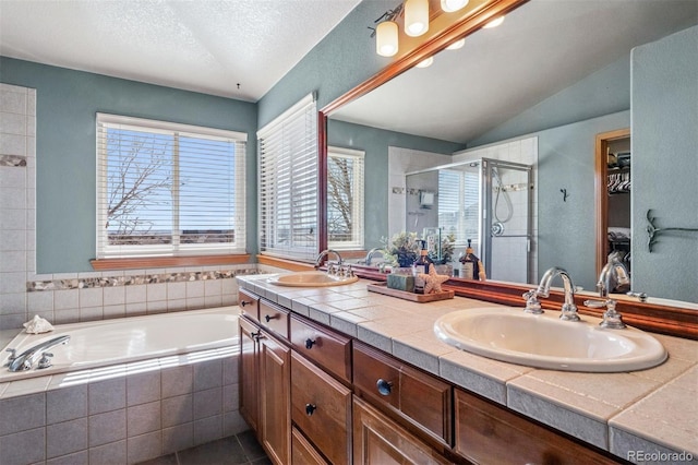 full bath featuring a garden tub, a sink, a shower stall, and double vanity