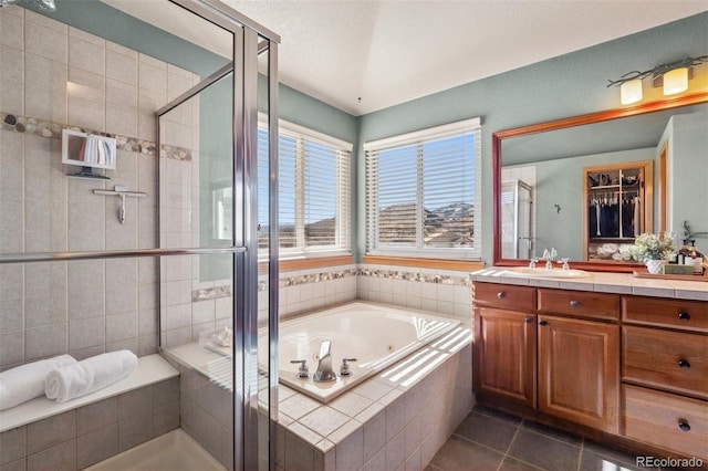 bathroom with a stall shower, a jetted tub, vanity, and tile patterned floors