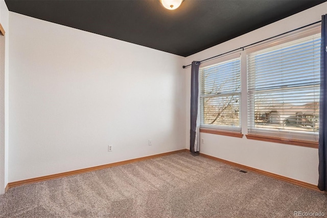 spare room with light carpet, visible vents, and baseboards