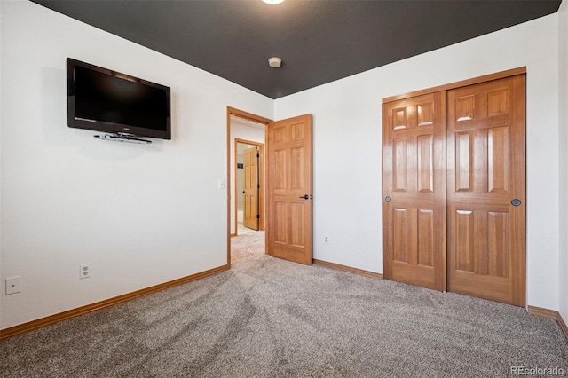 unfurnished bedroom featuring carpet flooring and baseboards