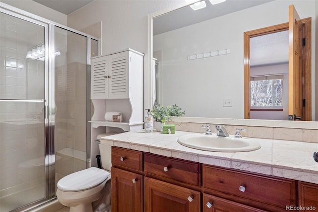 full bath featuring toilet, a stall shower, and vanity