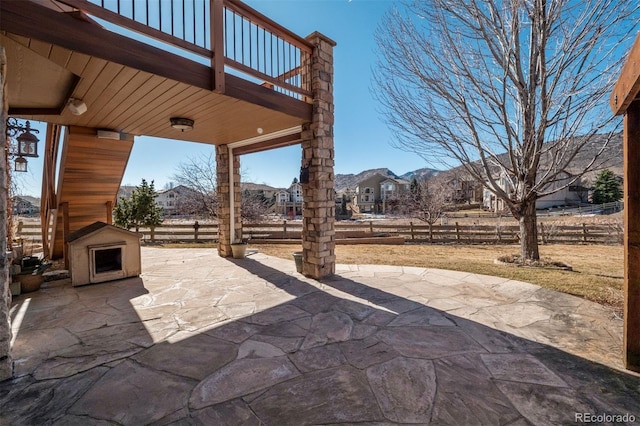 view of patio featuring a fireplace and fence