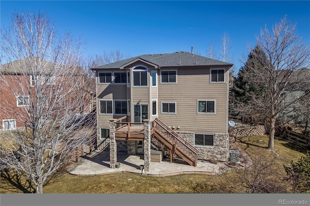 rear view of house featuring roof with shingles, a patio area, central AC, a deck, and stairs