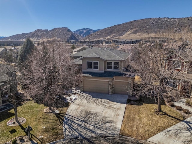 exterior space featuring concrete driveway, stone siding, roof with shingles, an attached garage, and a mountain view