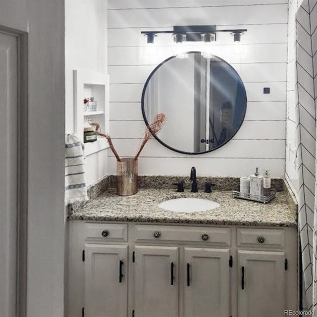 bathroom with vanity and wood walls