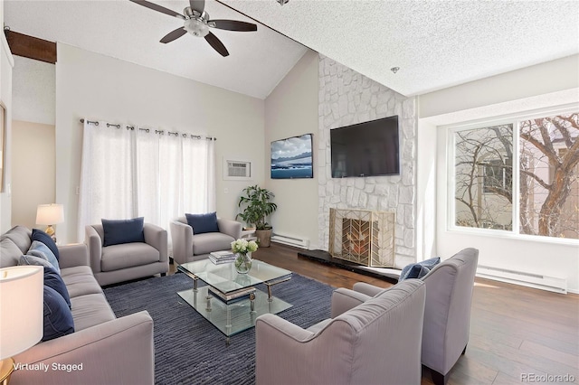 living area featuring plenty of natural light, lofted ceiling, baseboard heating, and a fireplace