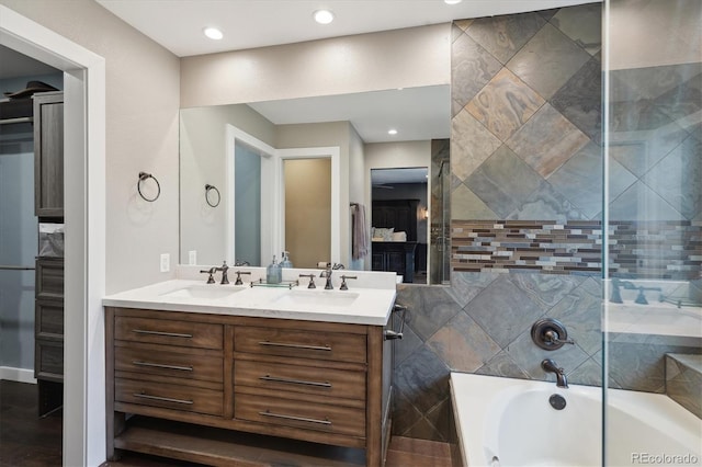 full bathroom featuring a bath, double vanity, and recessed lighting