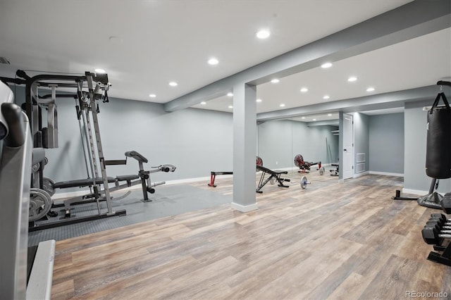 exercise room with baseboards, wood finished floors, and recessed lighting