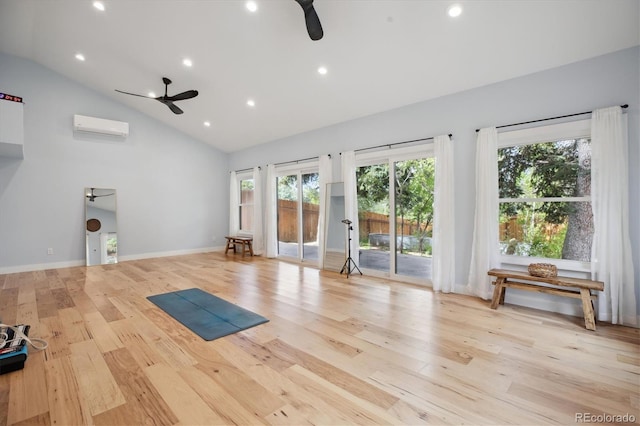 exercise area featuring a ceiling fan, an AC wall unit, high vaulted ceiling, light wood finished floors, and recessed lighting