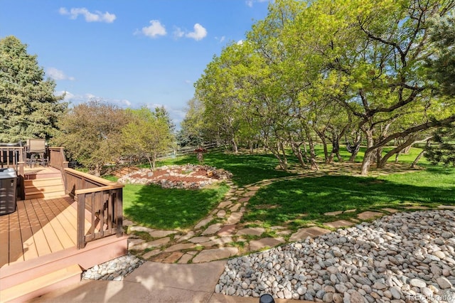 view of green lawn with a wooden deck