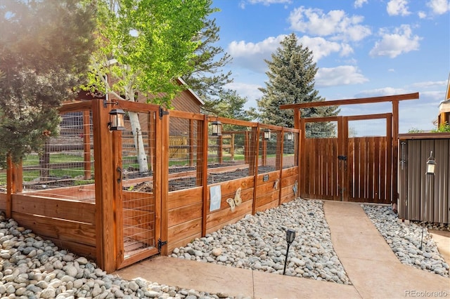 exterior space featuring a vegetable garden, fence, and a gate