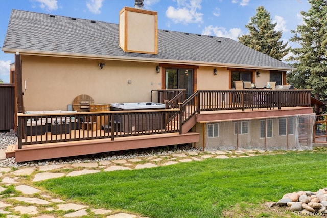 back of property featuring a deck, a yard, stucco siding, a chimney, and a shingled roof