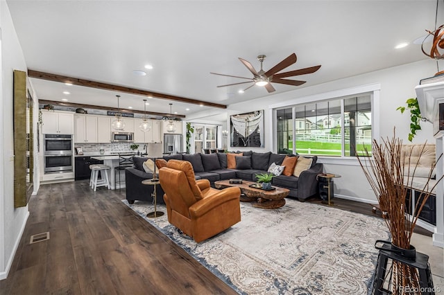 living area with dark wood-type flooring, beam ceiling, visible vents, and a ceiling fan