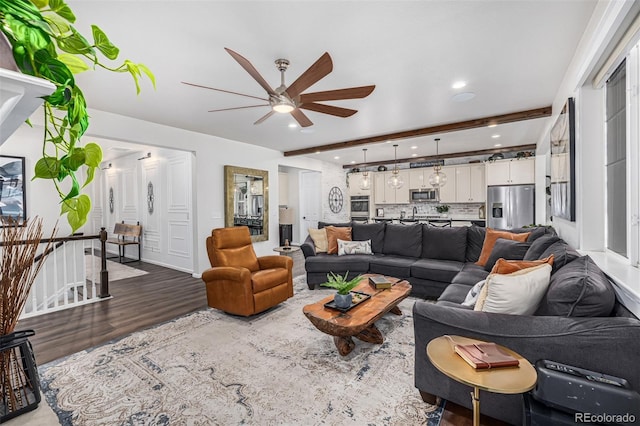 living area featuring a ceiling fan, recessed lighting, beamed ceiling, and wood finished floors