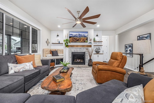 living area featuring recessed lighting, a ceiling fan, and a stone fireplace