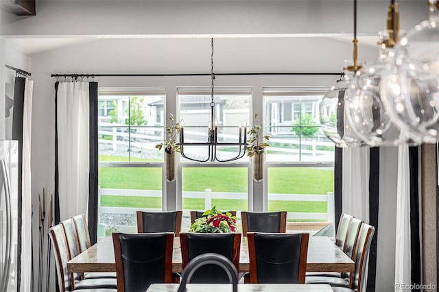 dining area with vaulted ceiling and a notable chandelier