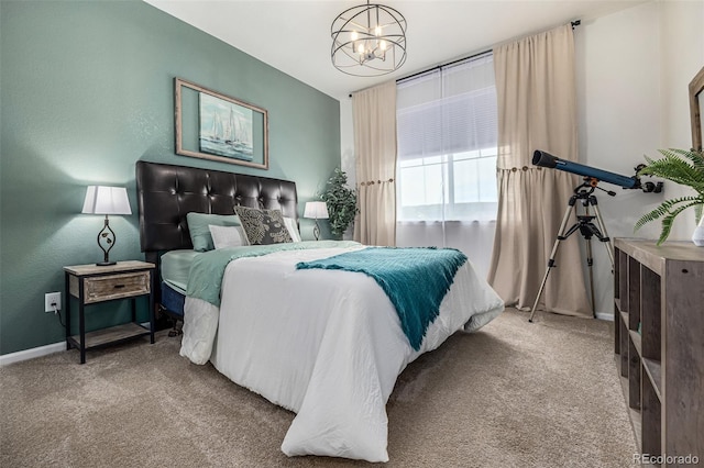 carpeted bedroom with baseboards and an inviting chandelier