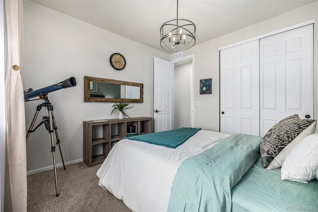 bedroom featuring a notable chandelier, a closet, baseboards, and carpet flooring