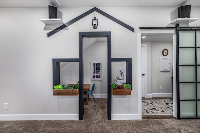 hall with carpet flooring, baseboards, and a barn door