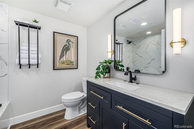 bathroom with toilet, wood finished floors, visible vents, and baseboards